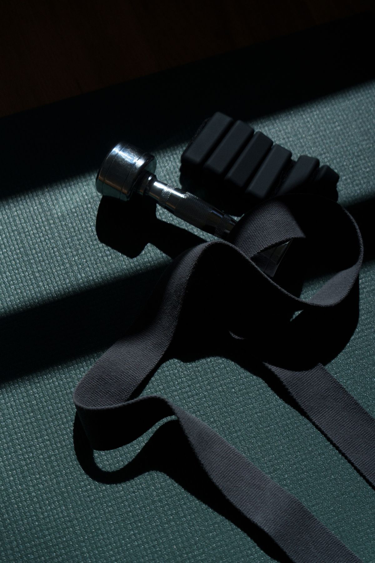 Halter e faixa de treino sobre um colchonete